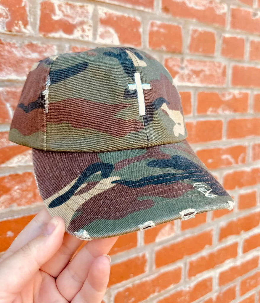 Distressed Camo Cross Hat - Style & Grace Co Distressed camo baseball hat with white embroidered cross on front"

"Christian cross camouflage cap with adjustable leather strap"

"Vintage style camo hat featuring faith-based cross design"

"Unisex distressed camo cross hat for casual and faith fashion"

"Faith-inspired camouflage baseball cap with worn look"

"Christian camo hat with embroidered white cross and brass buckle"

"Stylish religious camo cap with vintage distressed fabric"

"Adjustable camouflage
