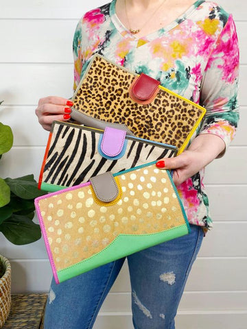 Nash Leather and Hair on Hide Travel Wallet - Multi Color - Style & Grace Co #1 best seller! Genuine leather wallet featuring bright colors and hair on hide detailing. Handmade in India.  Great for travel, documents, letters, etc. Card slots and clear pockets Interior zipper pockets and pen holder Fold over magnetic closure flap Approximately 9.5"x 5.5"